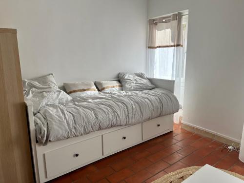 a bedroom with a white bed with pillows on it at La vue secrete de Neauphle in Neauphle-le-Château