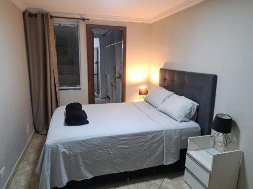 a bedroom with a bed with a black hat on it at Casa Grande Familia in Brasilia