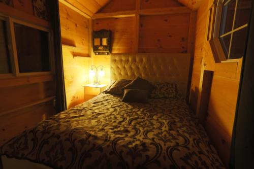 a small bedroom with a bed in a wooden room at Footprints Resort in Bancroft