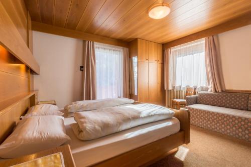 a bedroom with two beds and a couch at DOLOMITdreams in La Villa