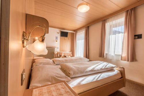 a row of four beds in a room at DOLOMITdreams in La Villa