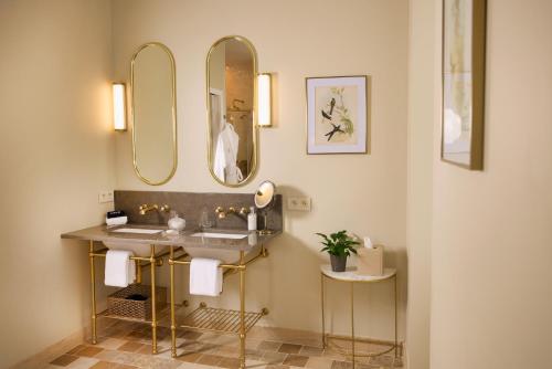 a bathroom with a sink and two mirrors at Maison 1896 in Beaune