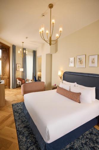 a bedroom with a large white bed and a chandelier at Maison 1896 in Beaune