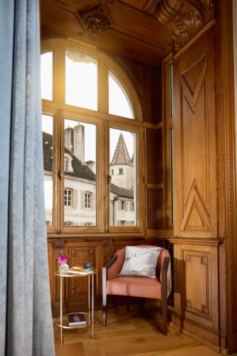 a chair in a room with a large window at Maison 1896 in Beaune