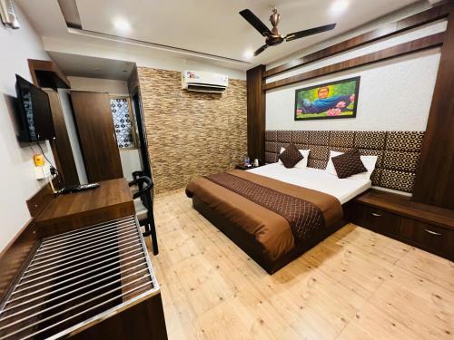 Hotel Sabera في سيليغري: غرفة نوم فيها سرير وتلفزيون