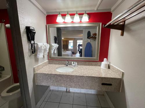 a bathroom with a sink and a mirror at Super 8 by Wyndham Monroe in Monroe