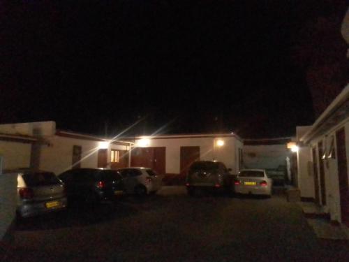 un estacionamiento frente a una casa por la noche en FEATHERS INN GUEST HOUSE, en Walvis Bay