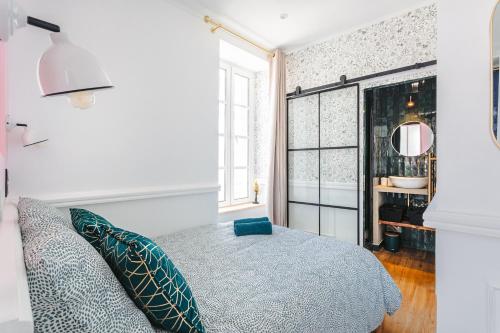 - une chambre avec un lit doté d'oreillers et d'un miroir dans l'établissement Le baroque Rochelais, à La Rochelle