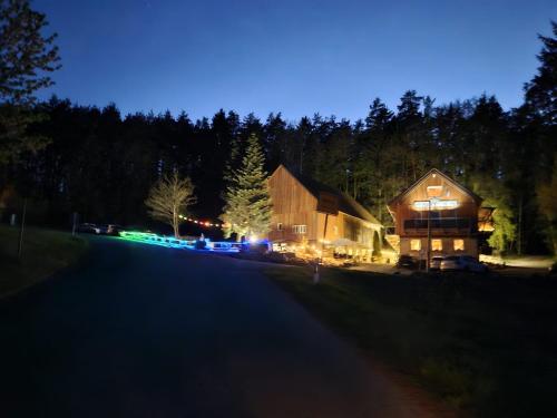 a large wooden barn at night with lights at Landgasthof Zur Linde in Kronach