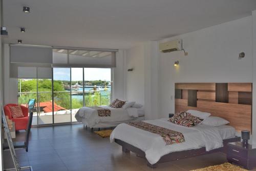 1 dormitorio con 2 camas y balcón en SeaSide Hotel, en Puerto Baquerizo Moreno