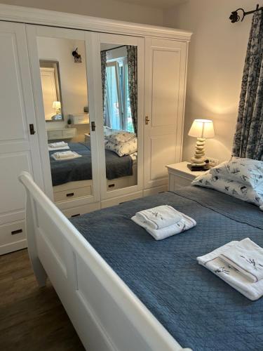 sypialnia z dwoma łóżkami i dużym lustrem w obiekcie Apartament Abi w mieście Vranjica