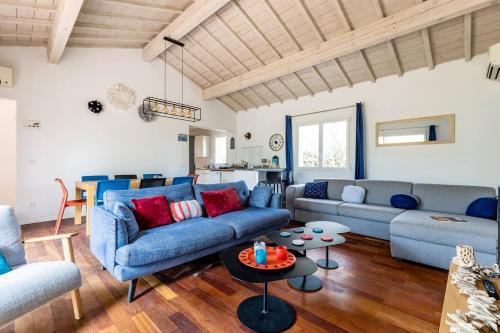 a living room with blue couches and a table at Villa Titoune, le charme du Coeur de Bassin, à 2 familles ou entre amis in Lanton