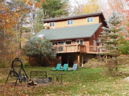 a log cabin with two chairs and a deck at Where Memories Are Made in West Kill