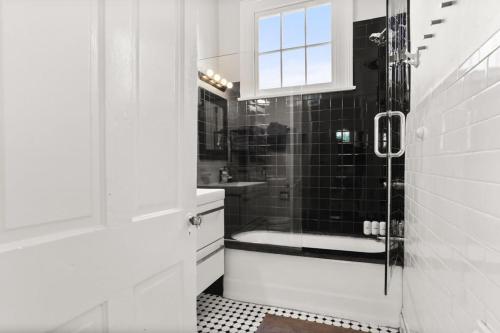 a black and white bathroom with a shower and a sink at Marigny BD Surrounded by Music Food and Art in New Orleans