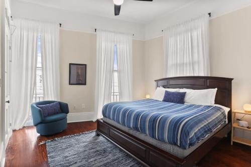 um quarto com uma cama e uma cadeira azul em Marigny BD Surrounded by Music Food and Art em Nova Orleães