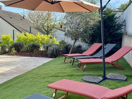 a group of chairs and an umbrella on a lawn at The villa of the Impressionists in Vernon
