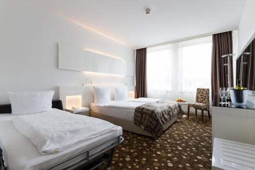 a hotel room with two beds and a window at Hotel Bayer's in Munich