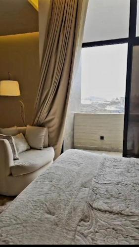 海米斯穆謝特的住宿－Modern villa فلتي حديثه，一间卧室配有一张床、一张沙发和一个窗口