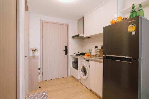 a kitchen with a refrigerator and a washing machine at Mini Jung Yama in Chiang Mai