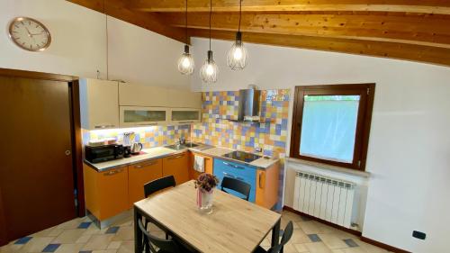 a kitchen with a table and a clock on the wall at ENJOY HOUSE in Ronchi