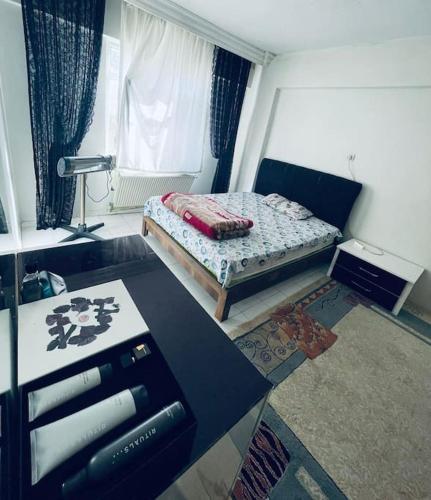 Habitación pequeña con cama y escritorio. en Diyarbakır bölgesinde konaklama en Diyarbakir