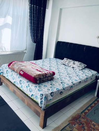 a bed with a blue headboard and pillows on it at Diyarbakır bölgesinde konaklama in Diyarbakır