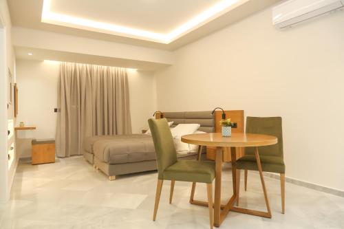 a living room with a table and a bed at Heaven Apartments in Agia Marina Nea Kydonias