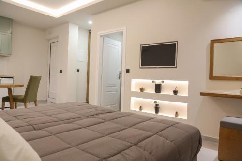 a bedroom with a large bed and a table at Heaven Apartments in Agia Marina Nea Kydonias
