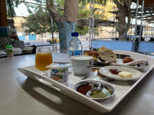 uma bandeja com comida de pequeno-almoço e uma bebida na mesa em Auberge-Cafe Tunisie em Nouakchott