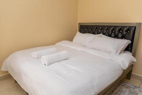ein großes weißes Bett mit zwei weißen Kissen darauf in der Unterkunft Cozy kahawa sukari in Nairobi