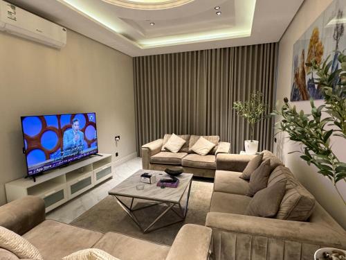 a living room with two couches and a flat screen tv at شقة فاخرة ٣ غرف وصالة دخول ذاتي ٩ in Riyadh