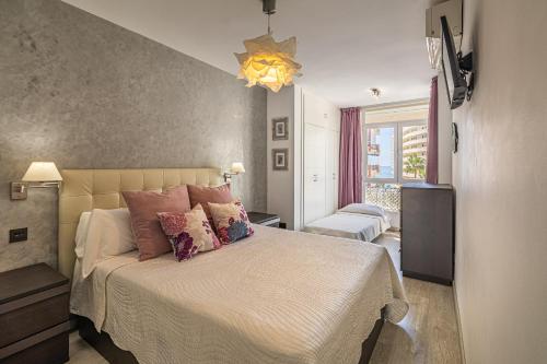 sypialnia z dużym łóżkiem z różowymi poduszkami w obiekcie City Center Apartment in Marbella w Marbelli