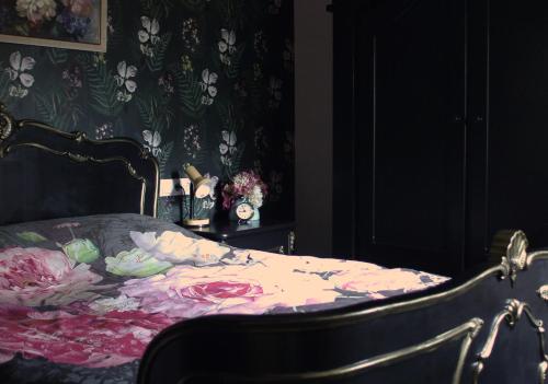 een slaapkamer met een bed met een bloemendeken bij 't Prentenhokkie in Stuifzand
