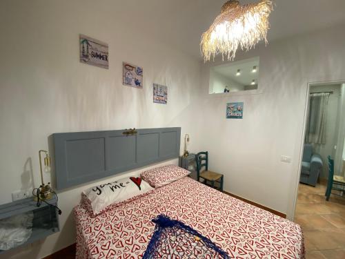 - une chambre avec un lit doté d'un couvre-lit rouge et blanc dans l'établissement Casa TYSANDROS Due passi dal mare, à Giardini Naxos