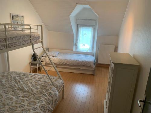 une chambre avec deux lits superposés et une fenêtre dans l'établissement Maison de pêcheur la CORBOE, à Étaples