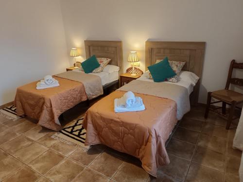 ein Hotelzimmer mit 2 Betten und Handtüchern darauf in der Unterkunft casa sierrecilla in Fuente de Piedra
