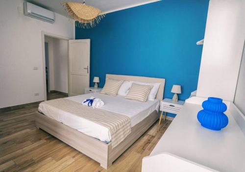 Schlafzimmer mit einem Bett mit blauer Wand in der Unterkunft Ad un passo dal molo in Porto Torres