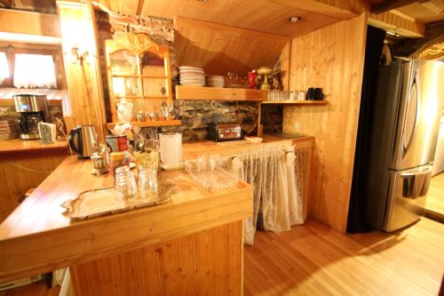 cocina con encimera de madera y nevera en B&B de la Fontaine, en Quebec