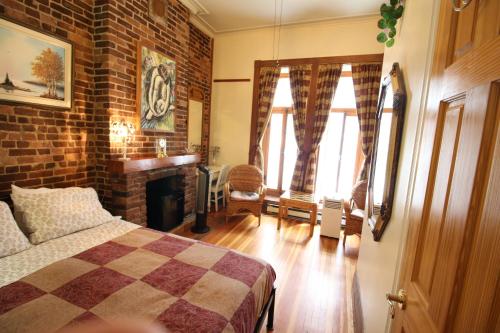 a bedroom with a bed and a brick wall at B&B de la Fontaine in Quebec City