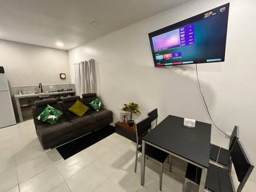 a living room with a couch and a tv on the wall at Apartamento equipado en zona privilegiada de Liberia in Liberia