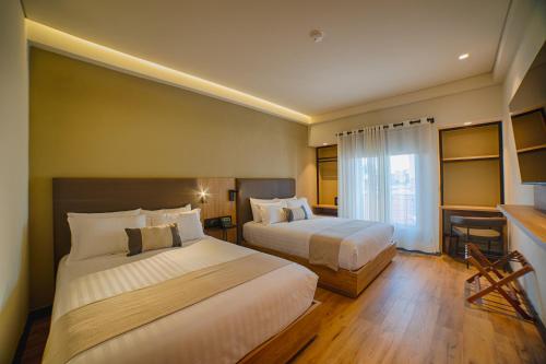 a hotel room with two beds and a window at HOTEL CASA ARANZAZU SAN LUIS POTOSI in San Luis Potosí