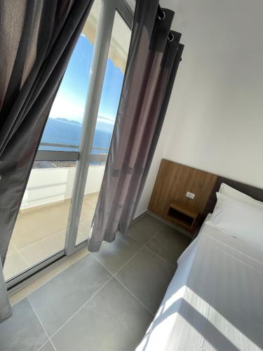 a bedroom with a bed and a view of the ocean at Hotel Kappa3 Villas in Vlorë
