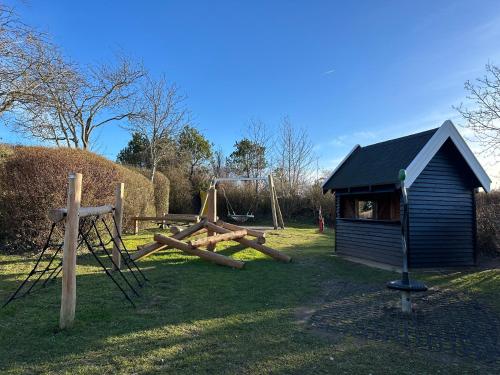 a playground with logs in front of a building at Lejlighed/rækkehus med adgang til pool. in Vipperød