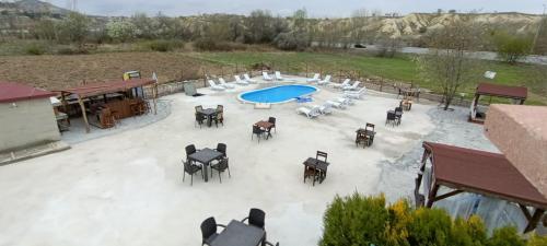 uma vista aérea de uma piscina com mesas e cadeiras em Cappadocia Cave Sinasos Villa em Mustafapaşa