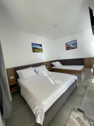 a bedroom with two beds with white sheets at Hotel Kappa3 Villas in Vlorë