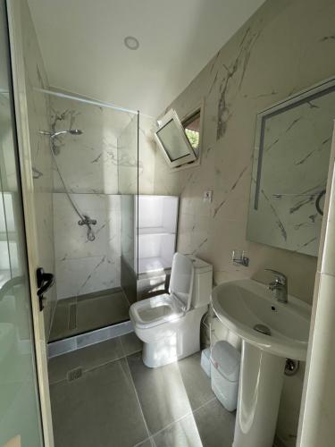 a bathroom with a toilet and a shower and a sink at Hotel Kappa3 Villas in Vlorë