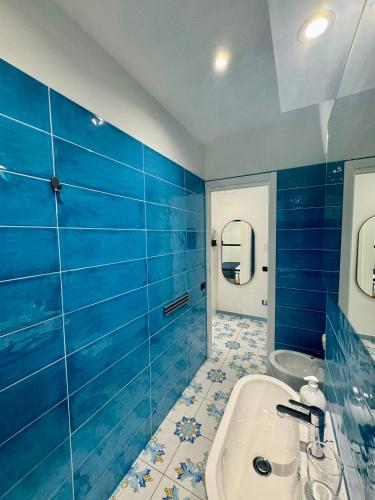 a blue bathroom with a tub and a sink at Panoramic Flat Amalfi Coast - Sea View 1 in Vietri sul Mare