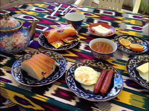 a table with plates of breakfast food on it at Modern Lux 2 in Samarkand