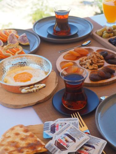 een tafel met borden met eten en drinken bij Kapalos Cave Hotel in Urgup