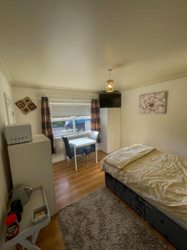 Un dormitorio con una cama y una mesa. en Valley View 2 NI Tourist board Registered, en Tamnyrankin